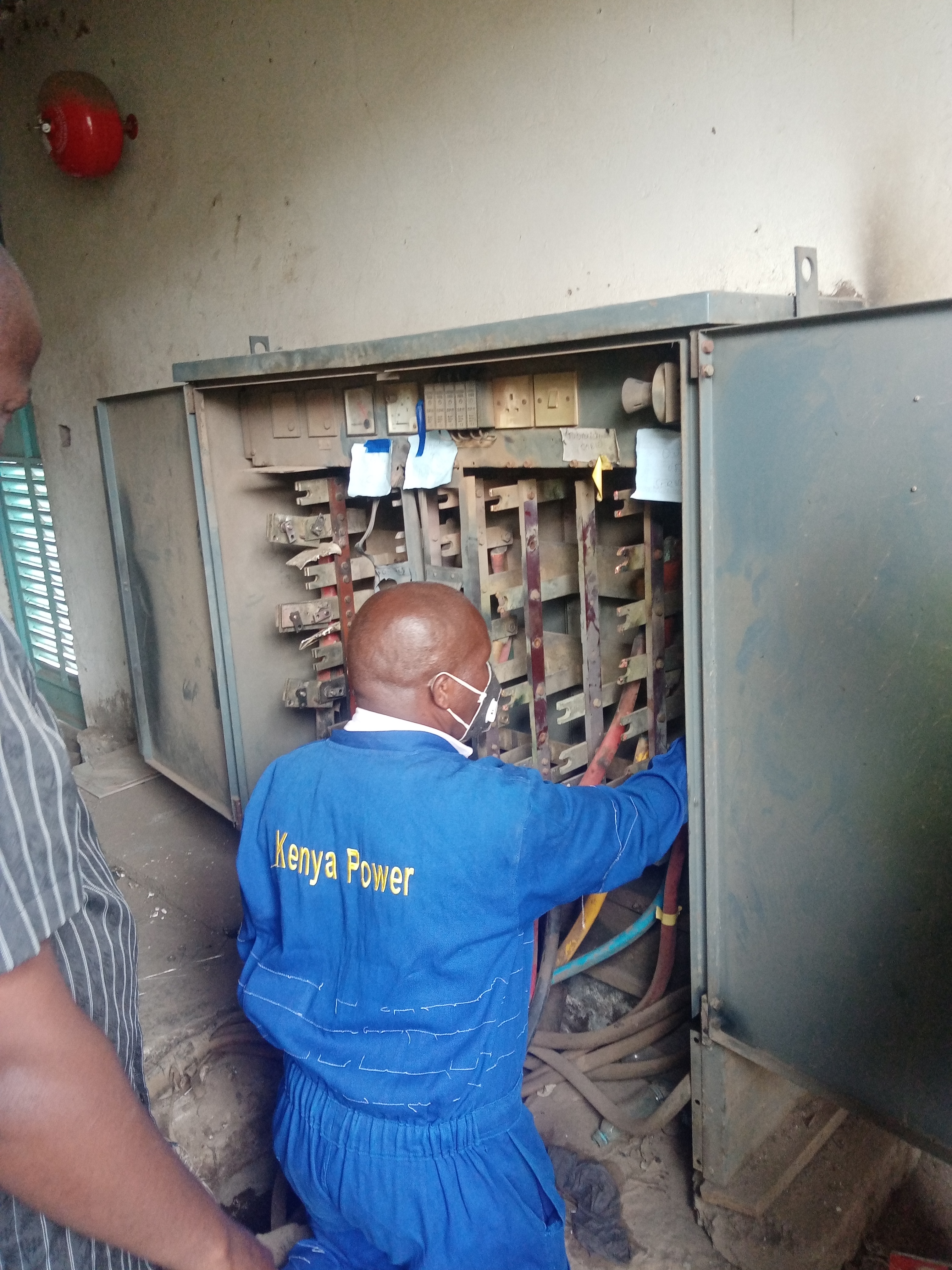 image of a kenya power technician handling a switching panel